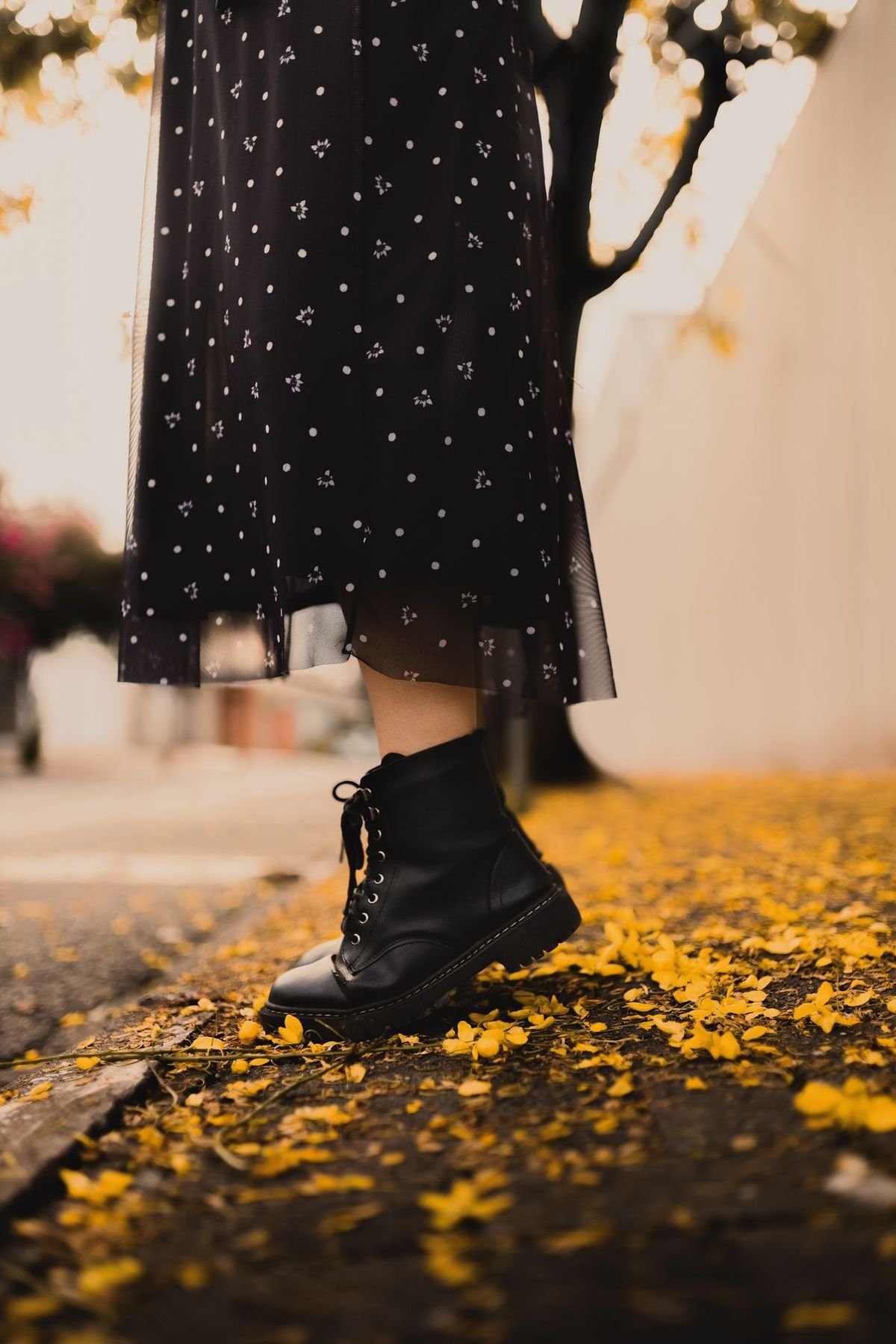 Black ankle boots worn with a polka dot midi dress in autumn