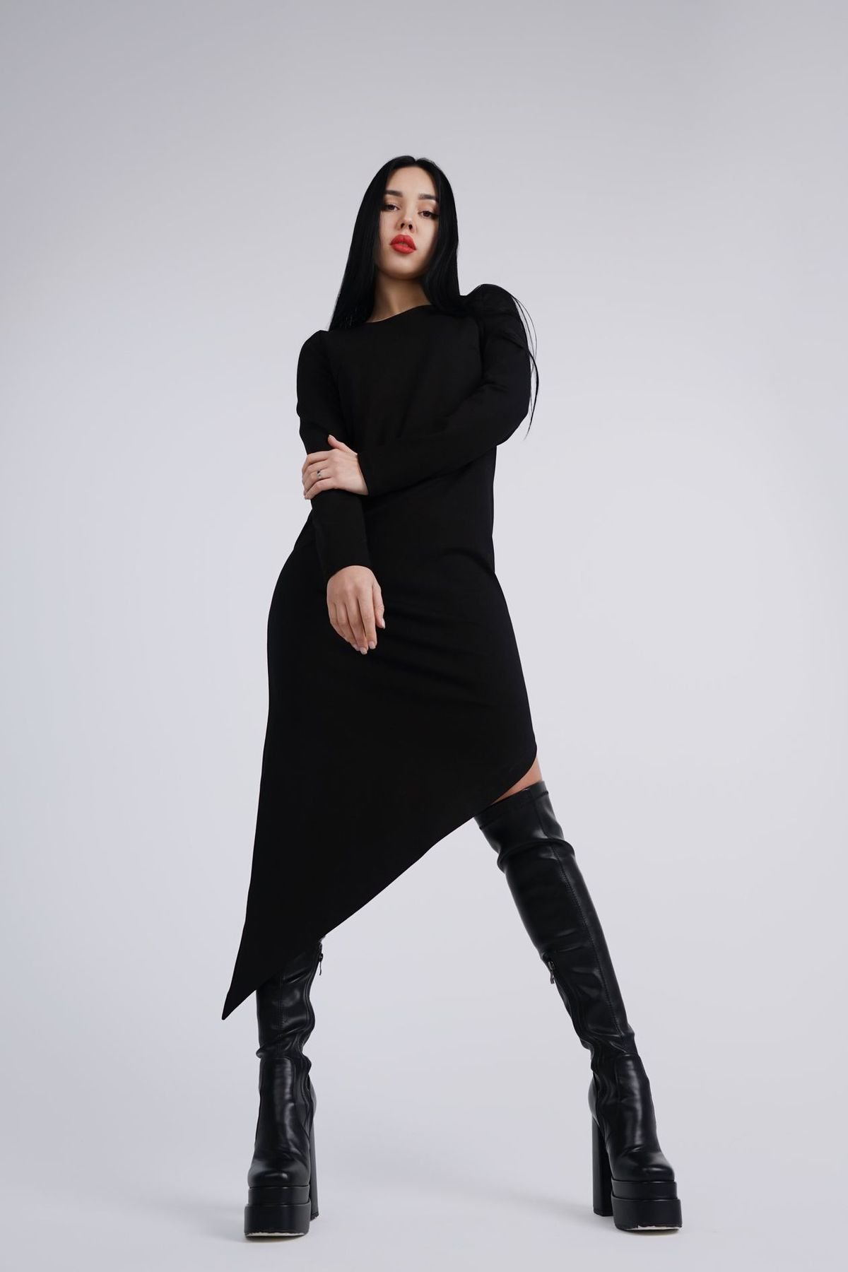 Woman in a black dress wearing black knee-high platform boots