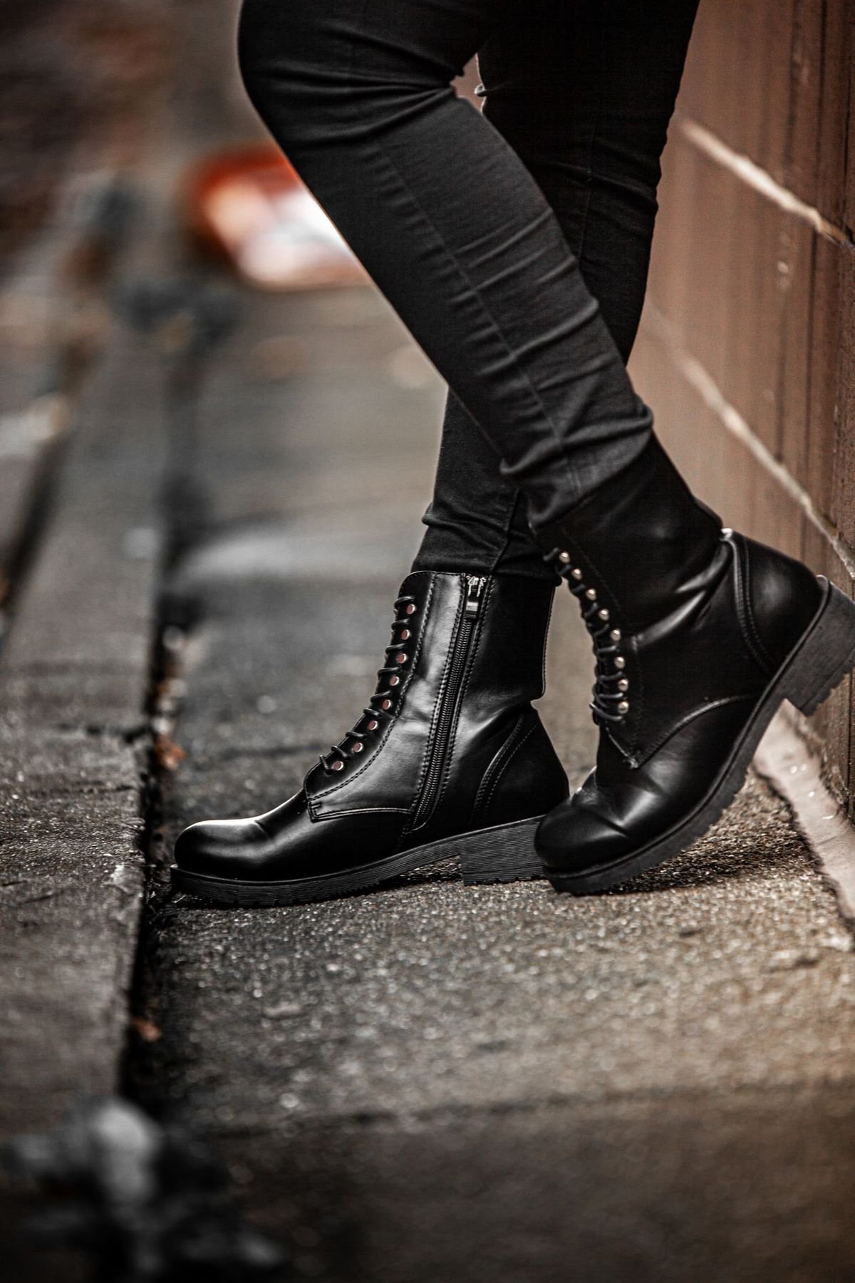 Black lace-up boots worn with black skinny jeans