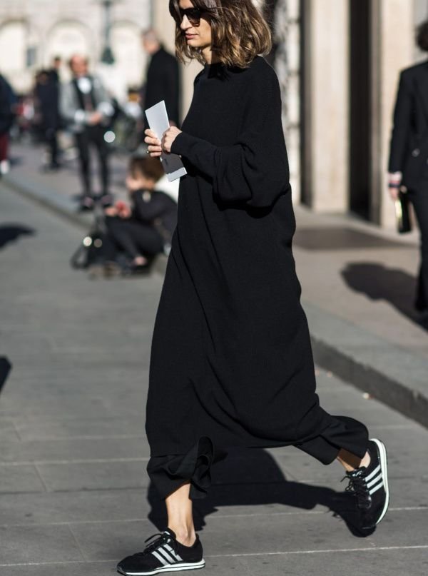 Woman wearing smart black trainers with a black work outfit