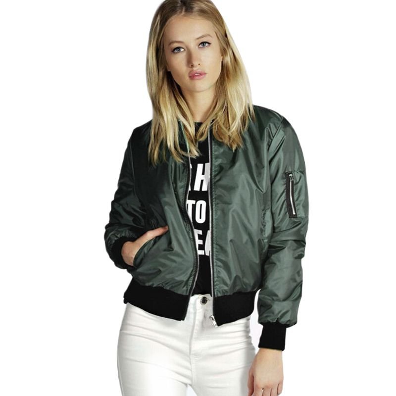 Woman wearing a green bomber jacket over a graphic top