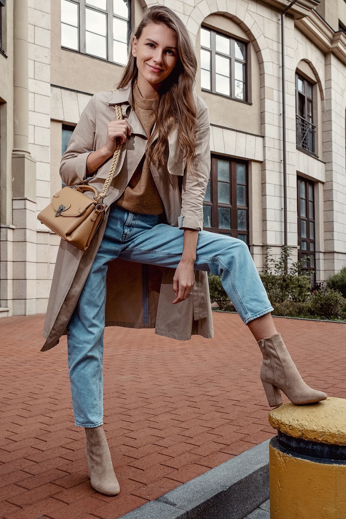 Woman wearing bootcut jeans with pointed ankle boots and a long coat
