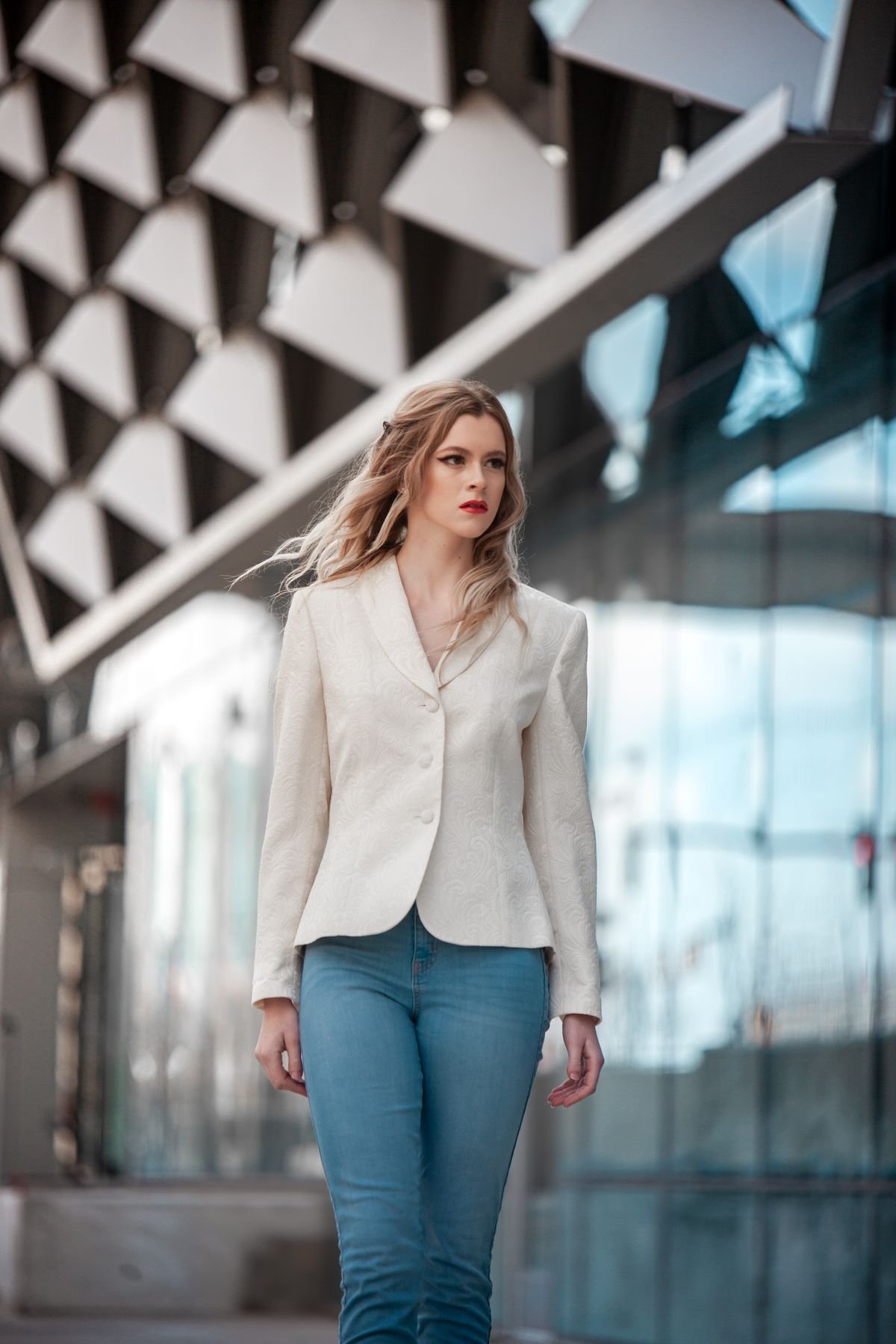 Woman in bootcut jeans with a tailored blazer and heeled boots