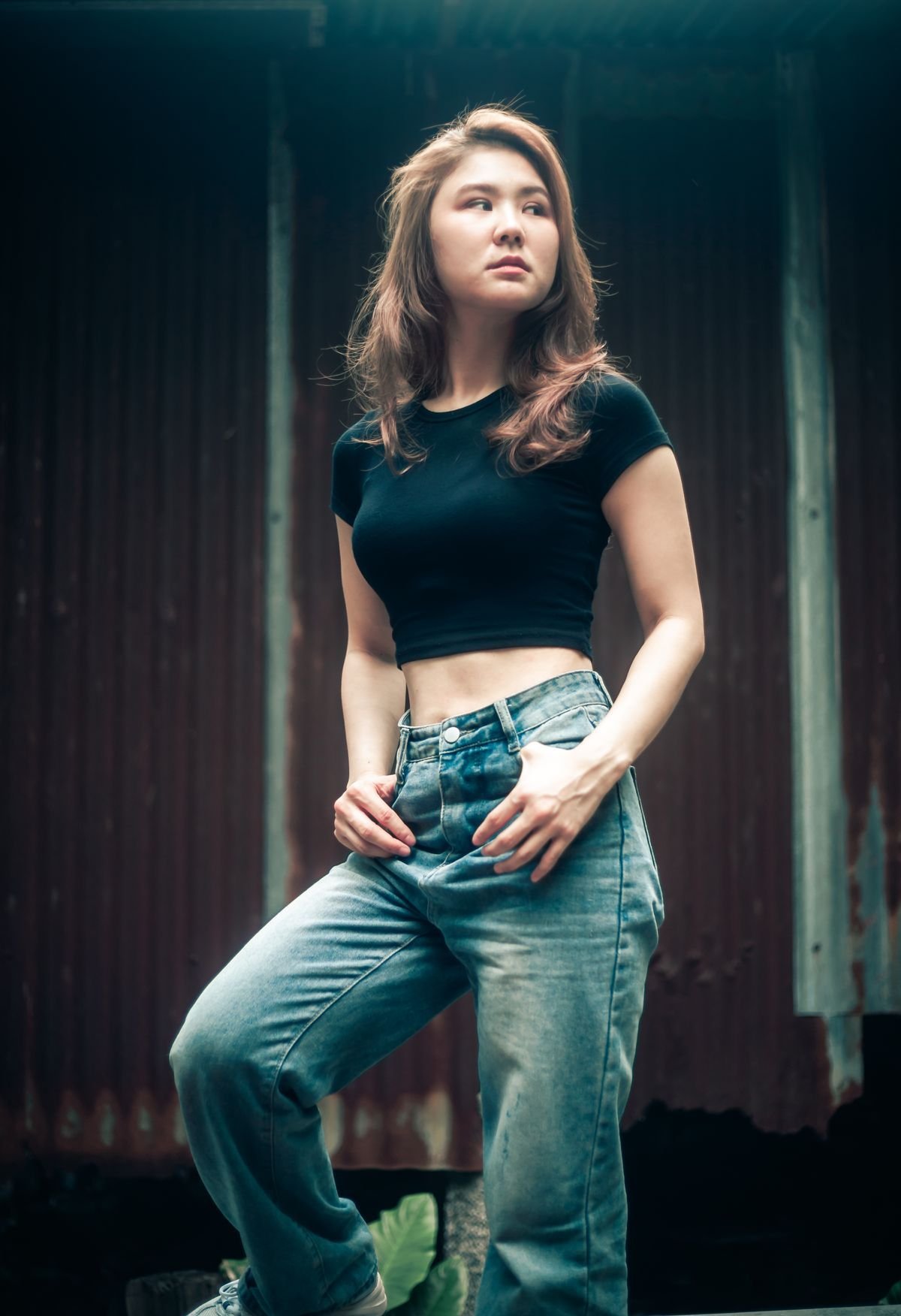 Woman in dark-wash bootcut jeans with a fitted black top