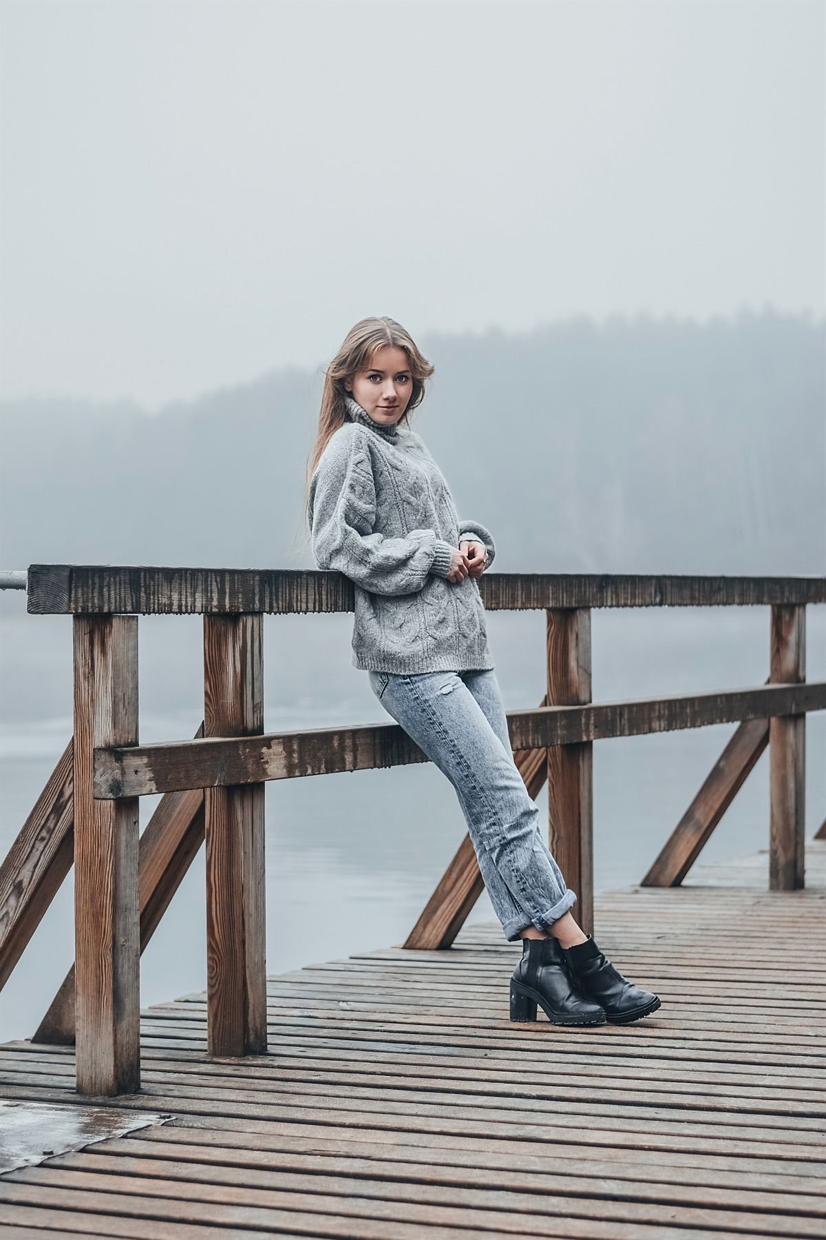 Woman in bootcut jeans with a chunky knit sweater