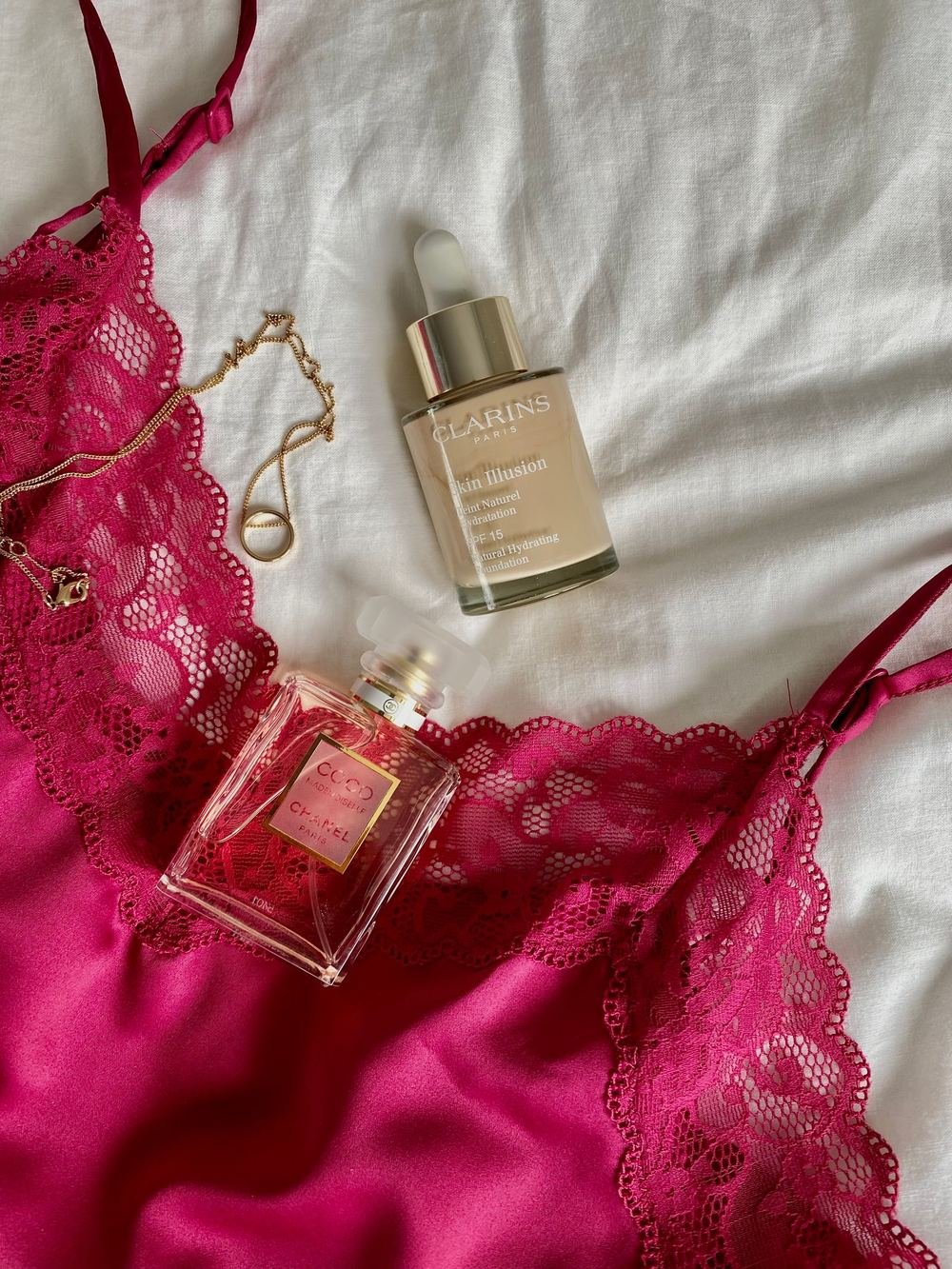 Elegant lace lingerie set with perfume on a neutral background for a bra fitting guide