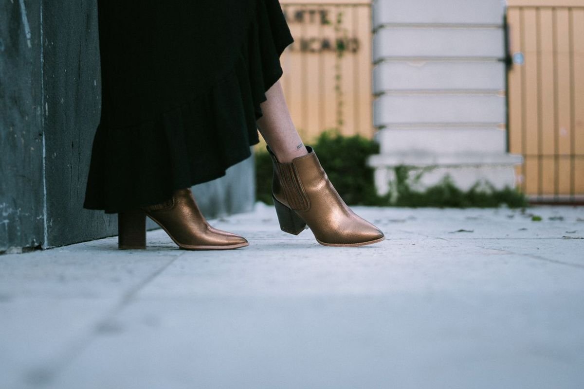 Woman wearing a black dress with brown knee-high boots