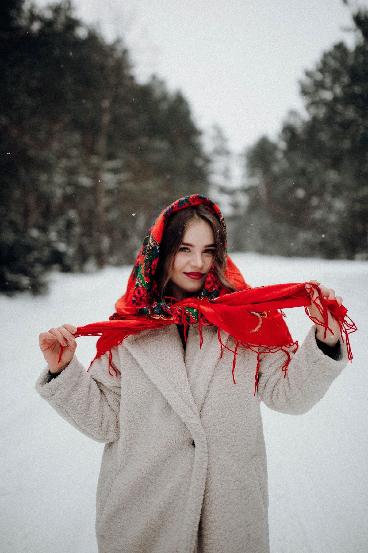 Woman in a camel coat with a tartan scarf and knee-high boots