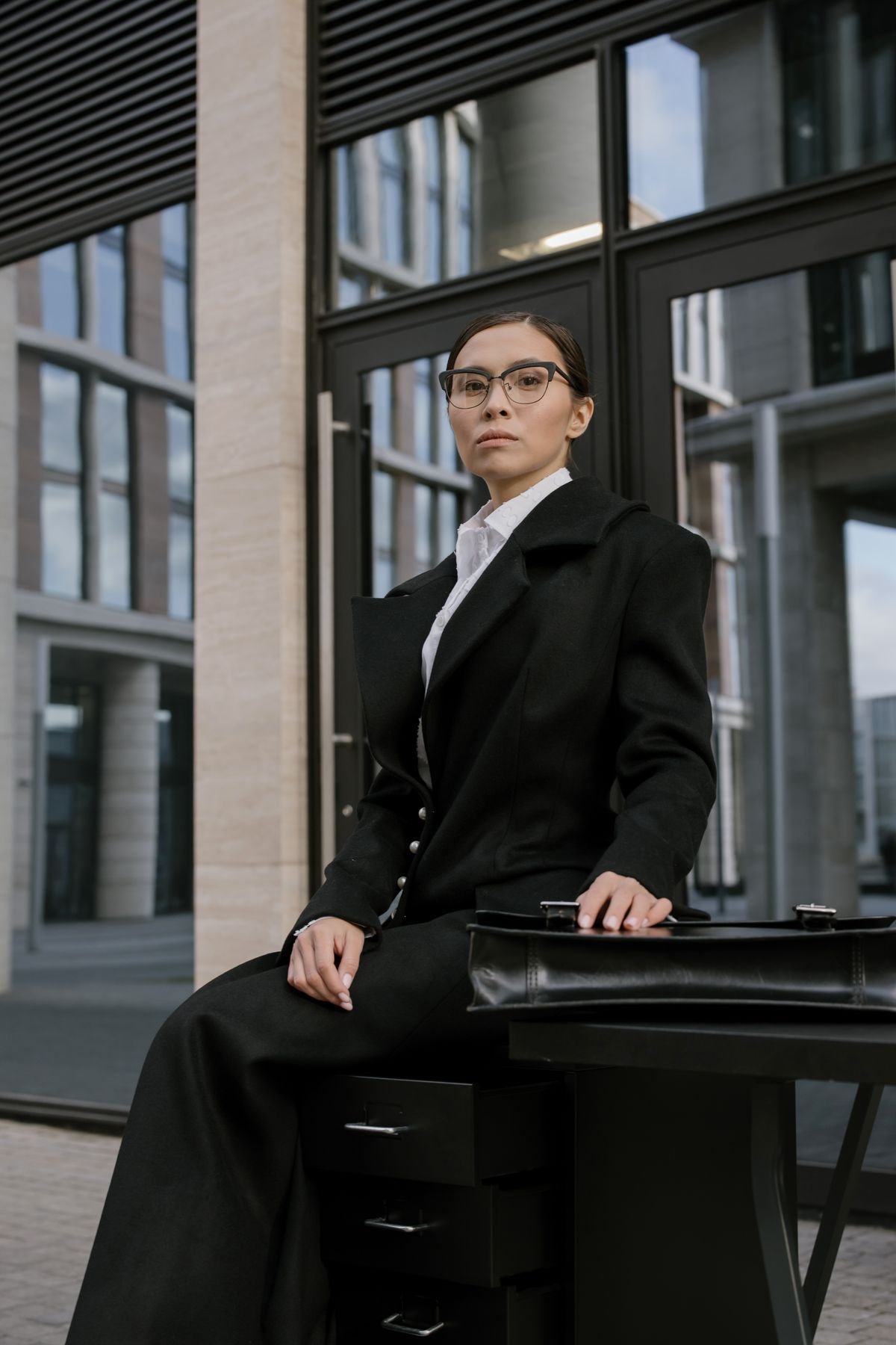 Woman in a camel coat over tailored work trousers