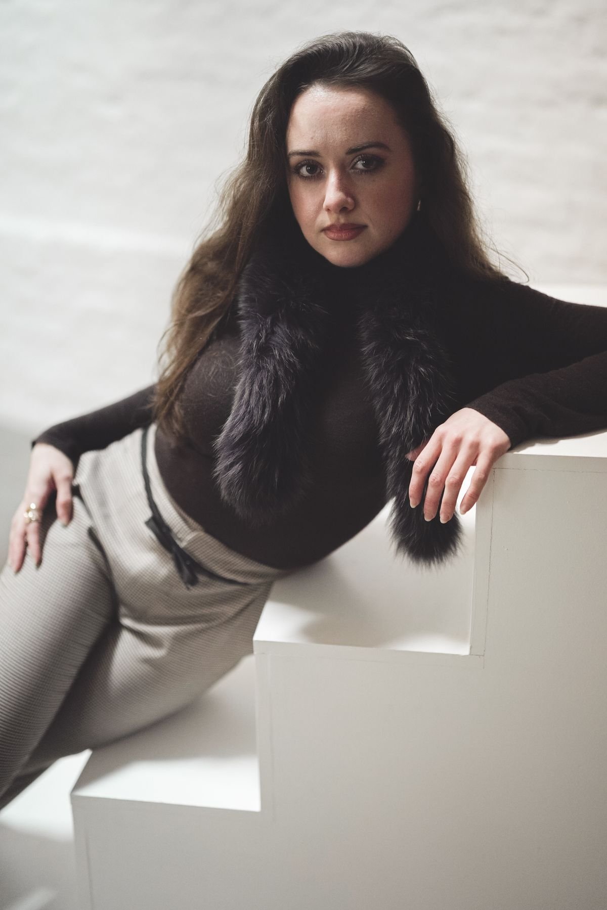 Elegant woman lounging with a fur scarf in a stylish outfit