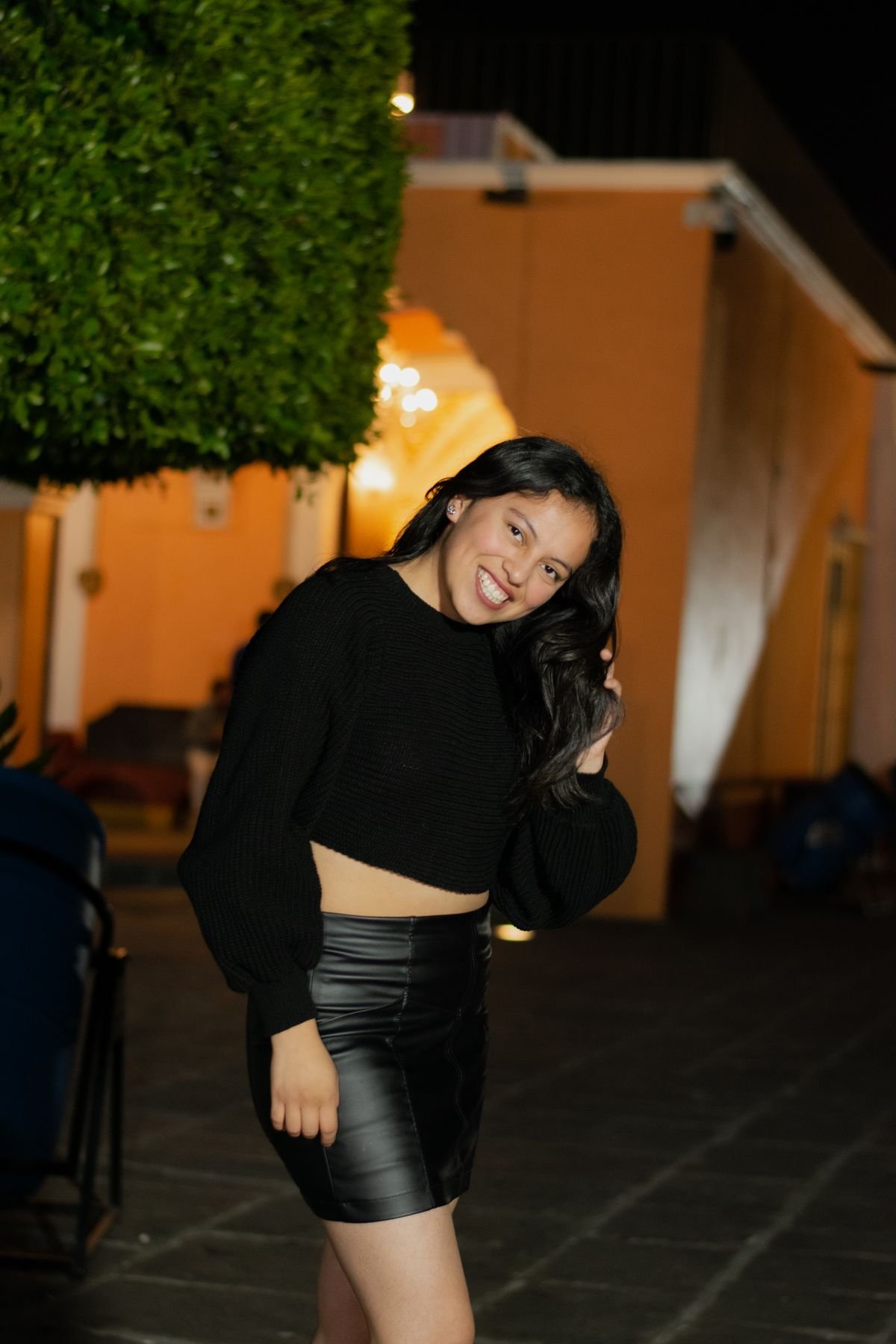Woman in a stylish outfit outdoors at night with glowing lights
