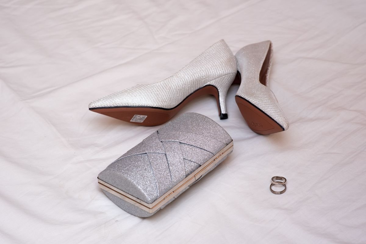 Silver heels, clutch and crystal jewellery beside a silver dress