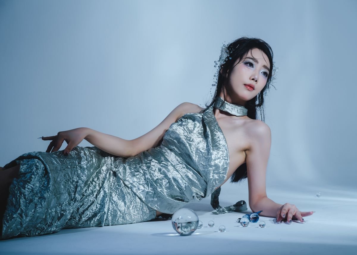 Woman wearing a silver midi dress with nude heels at an evening event