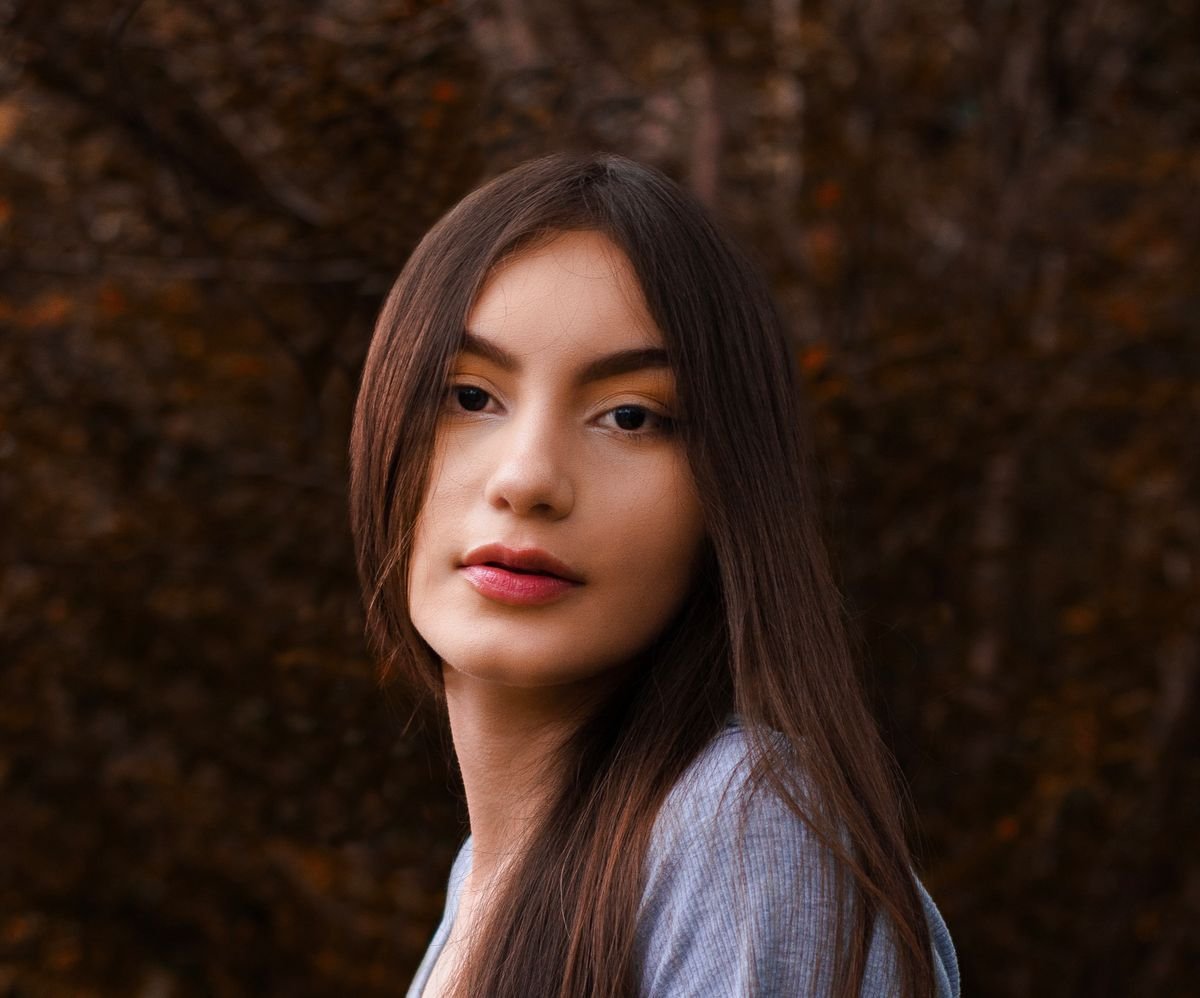 Close-up portrait of a young woman with long brunette hair