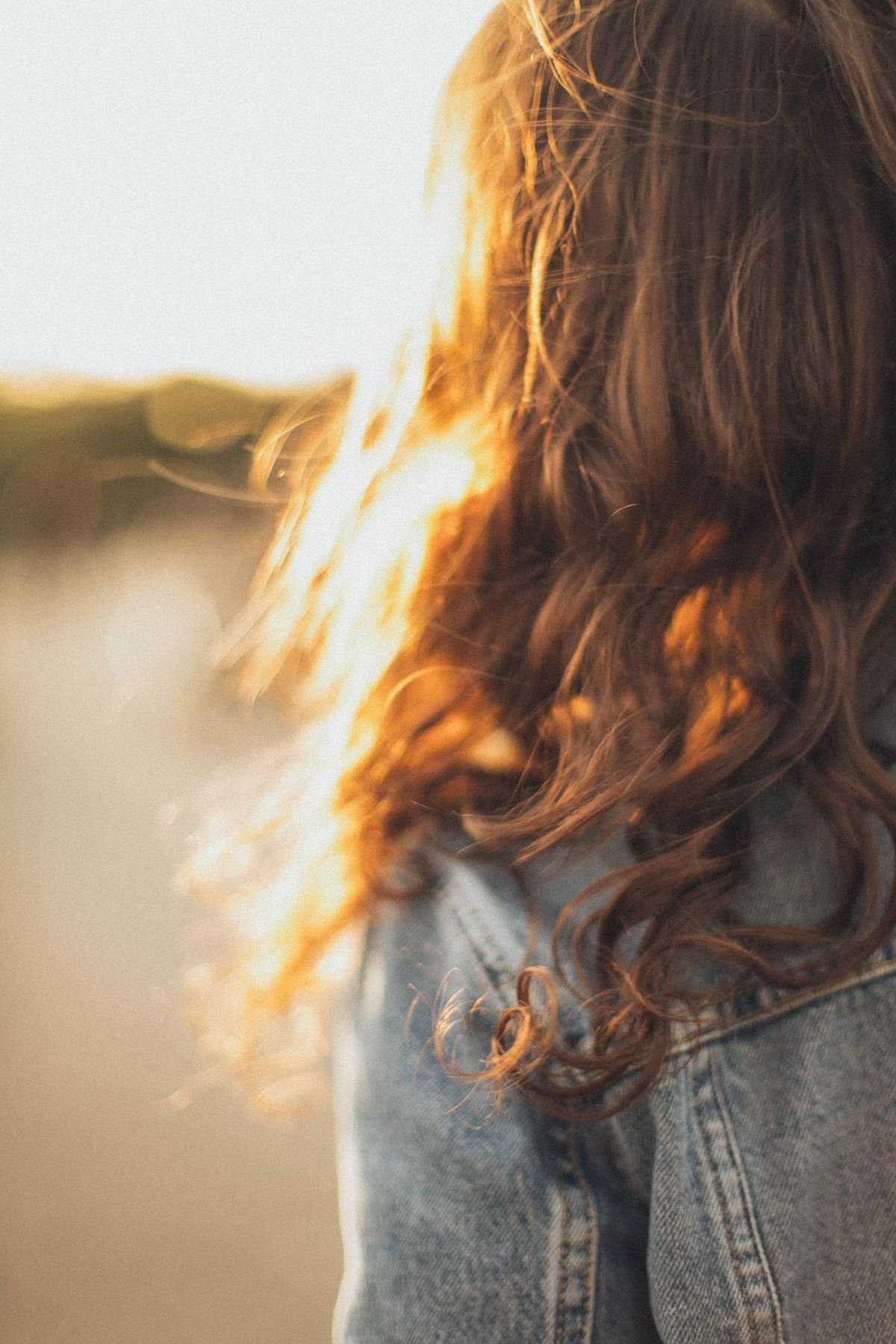 Woman with long wavy brunette hair in sunlight