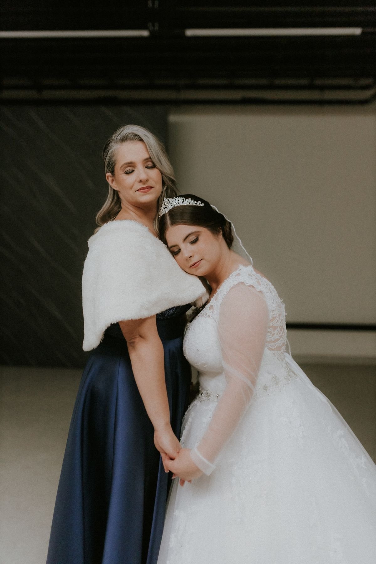 Two women in wedding dresses sharing a moment