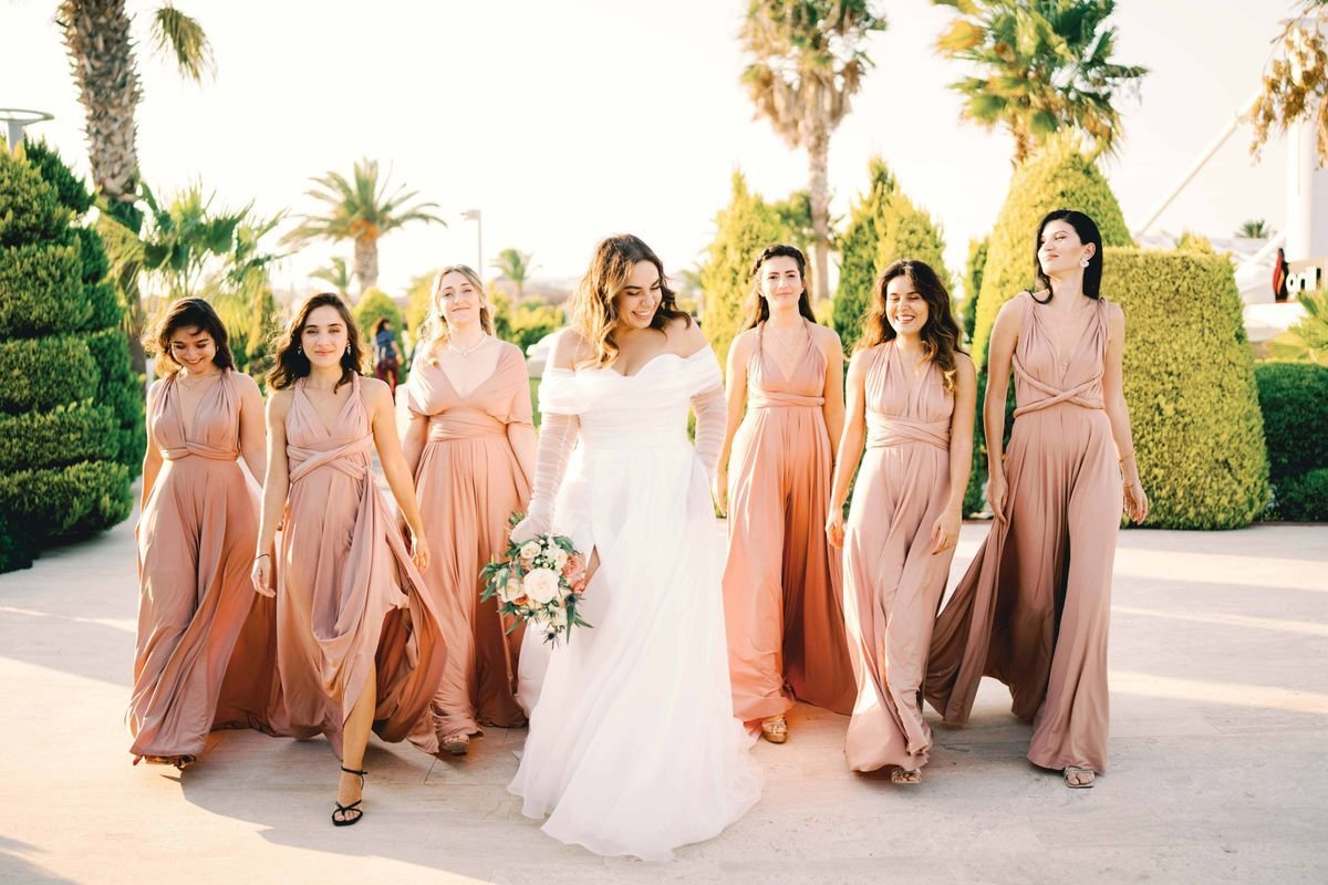 Bride and bridesmaids in light pink dresses outdoors